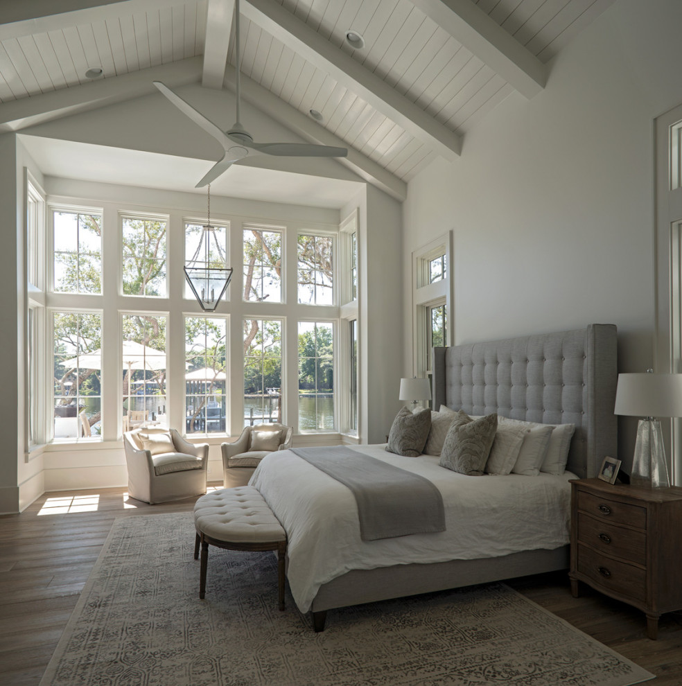 Design ideas for an expansive transitional master bedroom in Other with white walls, light hardwood floors, a standard fireplace, brown floor and vaulted.