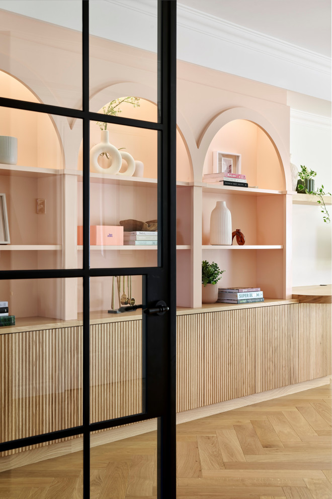 Diseño de despacho minimalista grande con paredes blancas, suelo de madera clara, escritorio empotrado, suelo marrón y bandeja