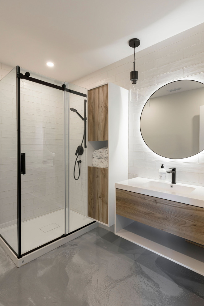 Exempel på ett mellanstort modernt vit vitt badrum med dusch, med släta luckor, skåp i ljust trä, en hörndusch, vit kakel, porslinskakel, vita väggar, betonggolv, ett integrerad handfat, grått golv och dusch med skjutdörr