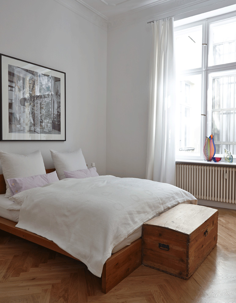 Design ideas for a mid-sized contemporary master bedroom in Berlin with white walls, light hardwood floors and no fireplace.