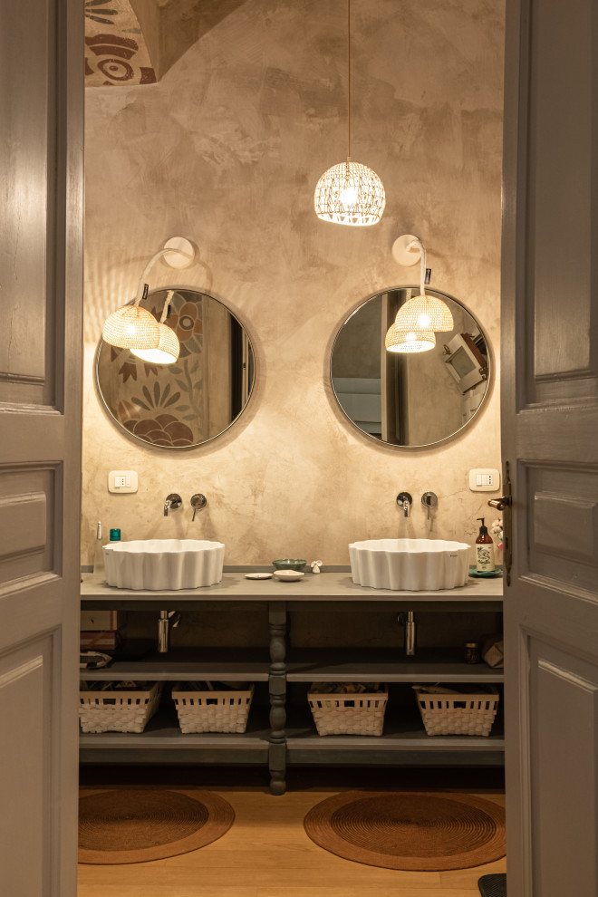 Photo of a mid-sized country master bathroom in Turin with white cabinets, an alcove shower, a two-piece toilet, beige tile, beige walls, medium hardwood floors, a vessel sink, wood benchtops, beige floor, a hinged shower door, green benchtops, a double vanity and vaulted.