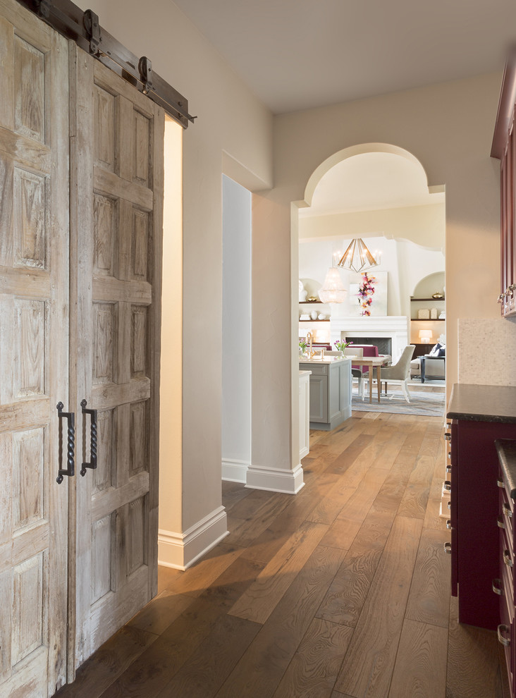 Inspiration for a mid-sized transitional hallway in Austin with beige walls, medium hardwood floors and brown floor.