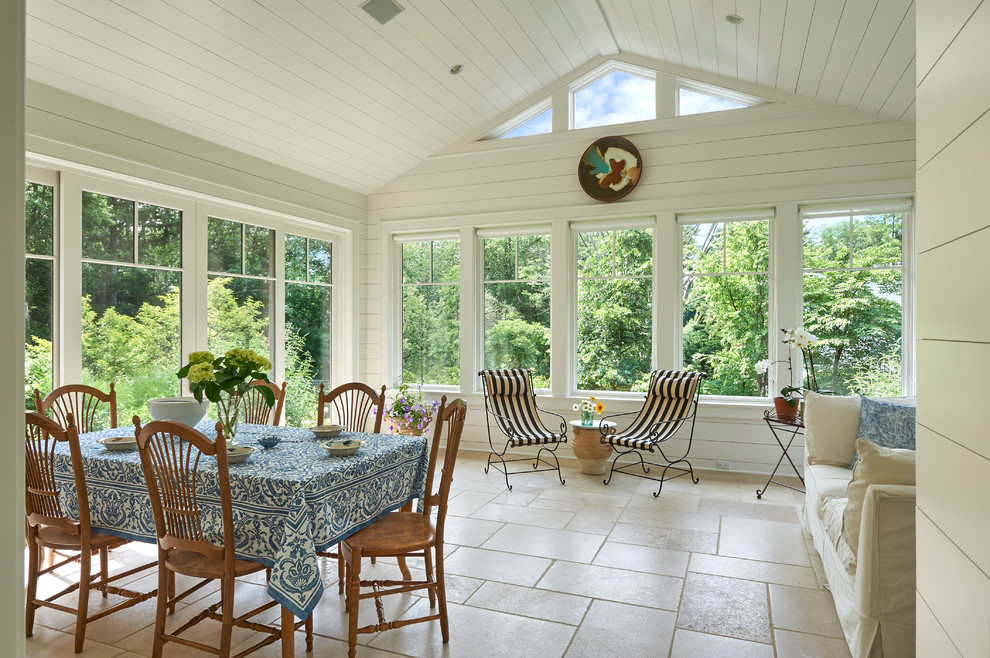 Large arts and crafts sunroom in New York with limestone floors, no fireplace, a standard ceiling and beige floor.