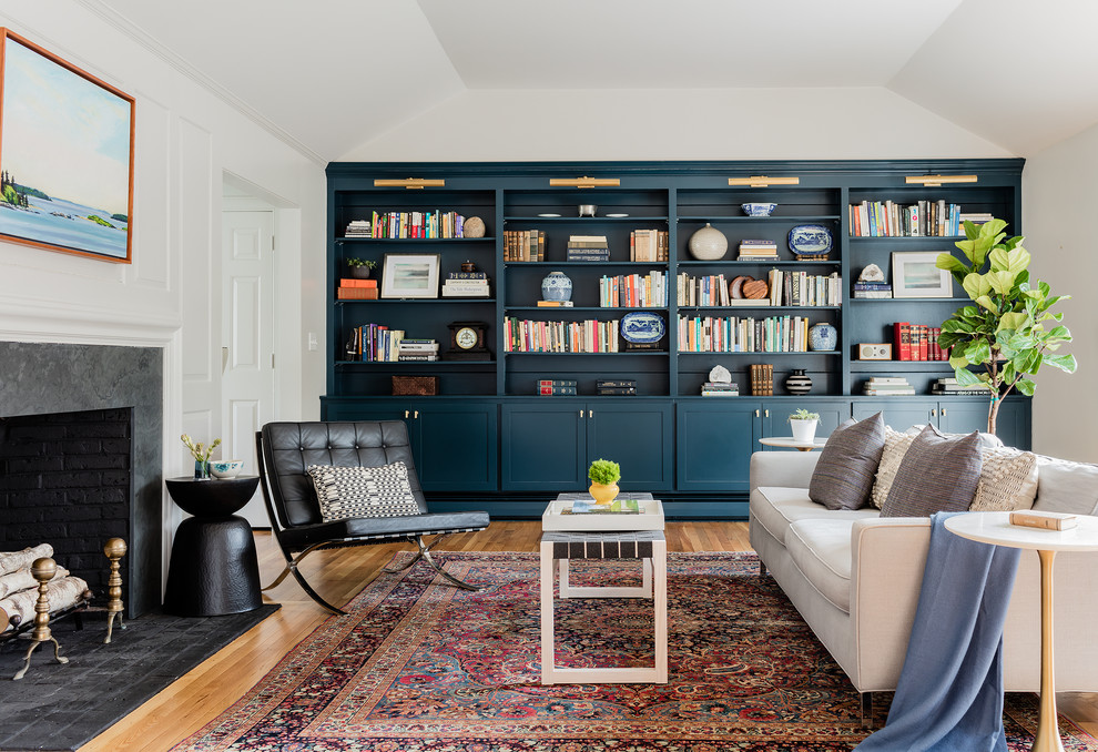 Inspiration for a transitional enclosed living room in Boston with a library, medium hardwood floors, a standard fireplace, a stone fireplace surround, white walls and brown floor.