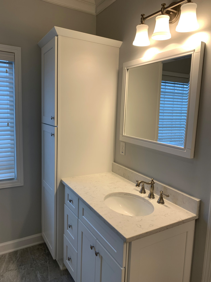 Inspiration for a mid-sized transitional master bathroom in Atlanta with shaker cabinets, white cabinets, a freestanding tub, a corner shower, a two-piece toilet, gray tile, porcelain tile, grey walls, terra-cotta floors, an undermount sink, engineered quartz benchtops, grey floor, a hinged shower door and white benchtops.