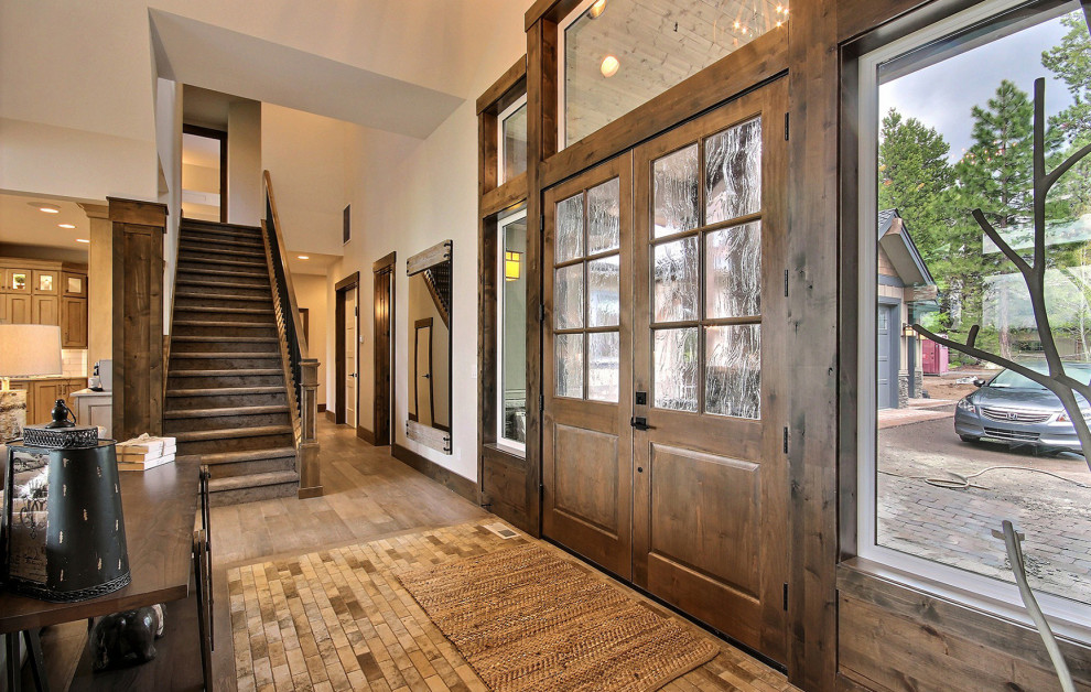 ポートランドにある高級な巨大なトラディショナルスタイルのおしゃれな玄関ドア (ベージュの壁、コンクリートの床、濃色木目調のドア、ベージュの床、三角天井、パネル壁) の写真