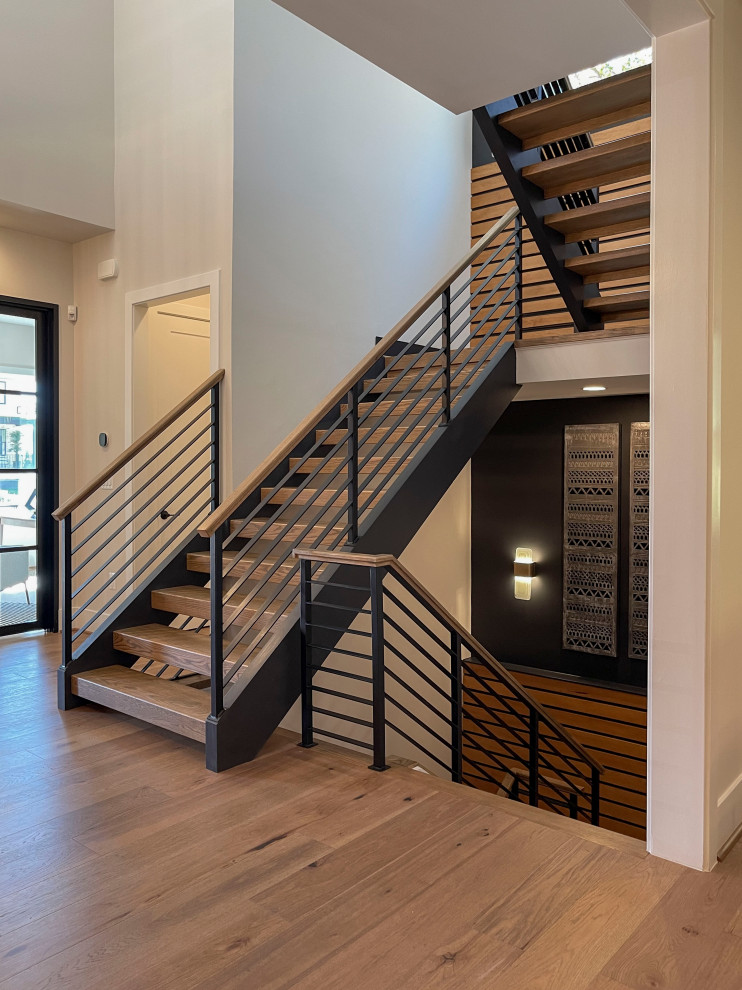 Inspiration pour un grand escalier droit design avec des marches en bois, un garde-corps en matériaux mixtes et du lambris.