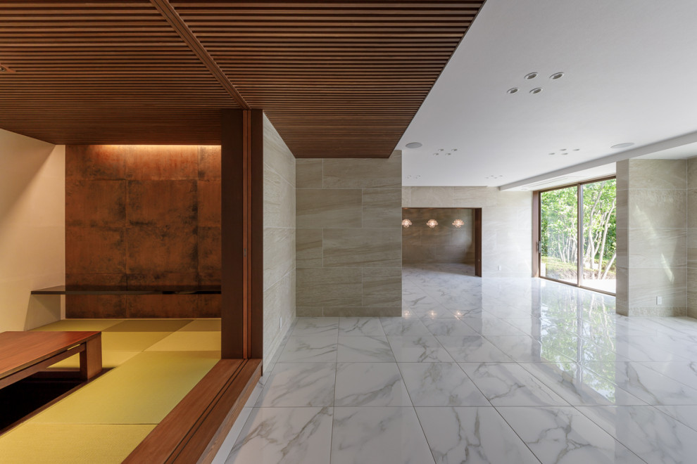 Стильный дизайн: большая открытая гостиная комната в восточном стиле с бежевыми стенами, полом из керамической плитки, белым полом и потолком с обоями - последний тренд