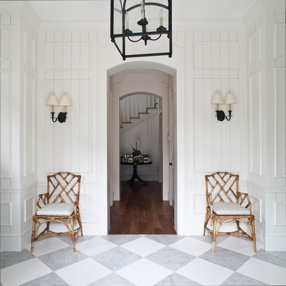 Tropical entryway in Miami with white walls, marble floors and multi-coloured floor.