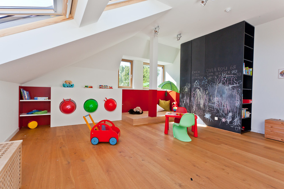 Large contemporary kids' playroom in Cologne with light hardwood floors for kids 4-10 years old and boys.