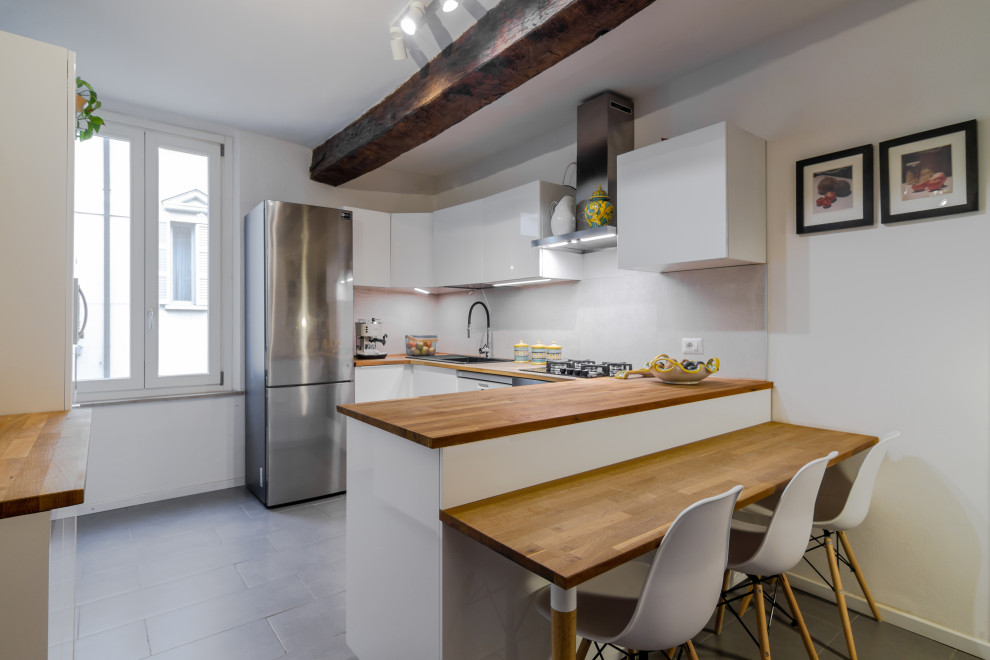 Idéer för ett u-kök, med vita skåp, träbänkskiva, klinkergolv i porslin och grått golv