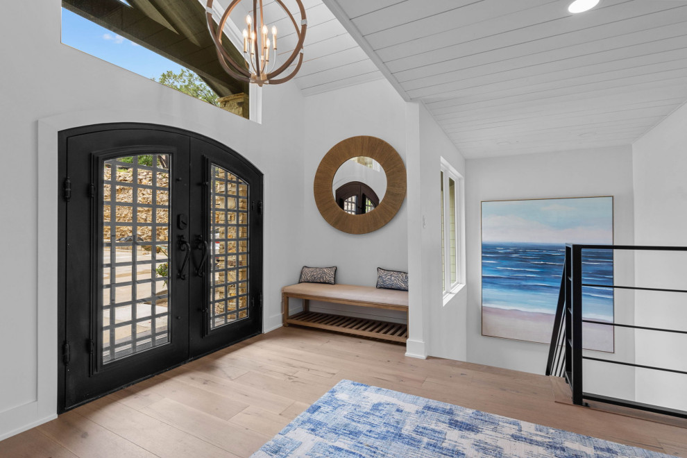 ダラスにある高級な広いトランジショナルスタイルのおしゃれな玄関ドア (白い壁、淡色無垢フローリング、黒いドア、茶色い床、塗装板張りの天井) の写真