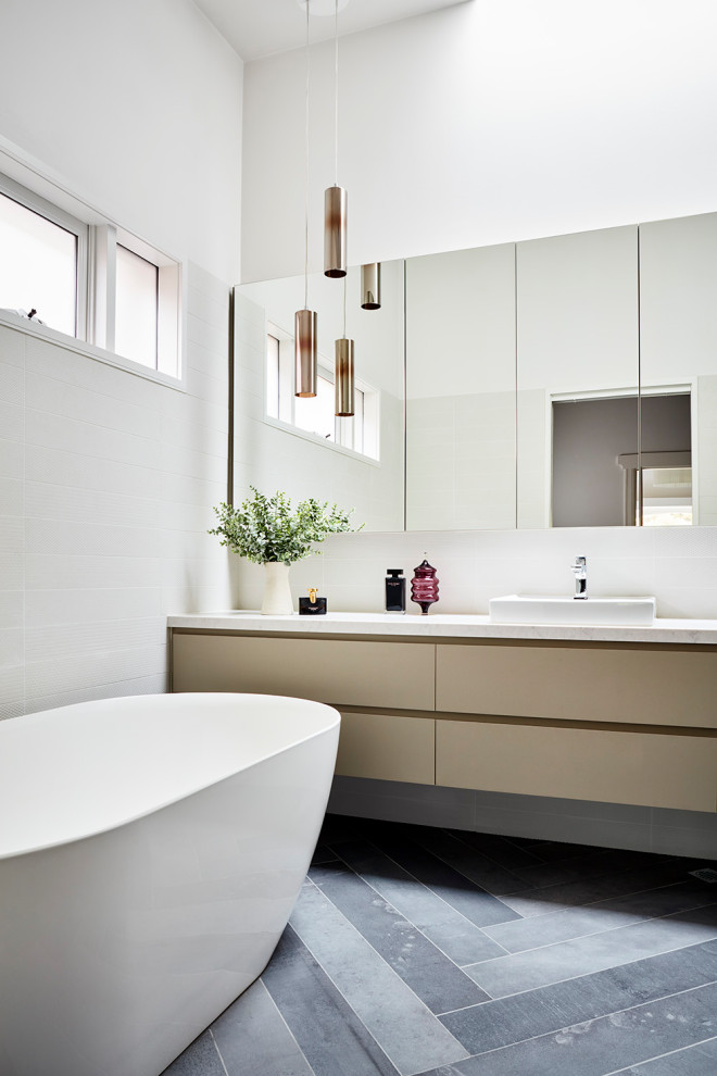 This is an example of a mid-sized contemporary master bathroom in Melbourne with flat-panel cabinets, beige cabinets, a freestanding tub, white walls, a vessel sink, grey floor, white benchtops, a single vanity and a floating vanity.
