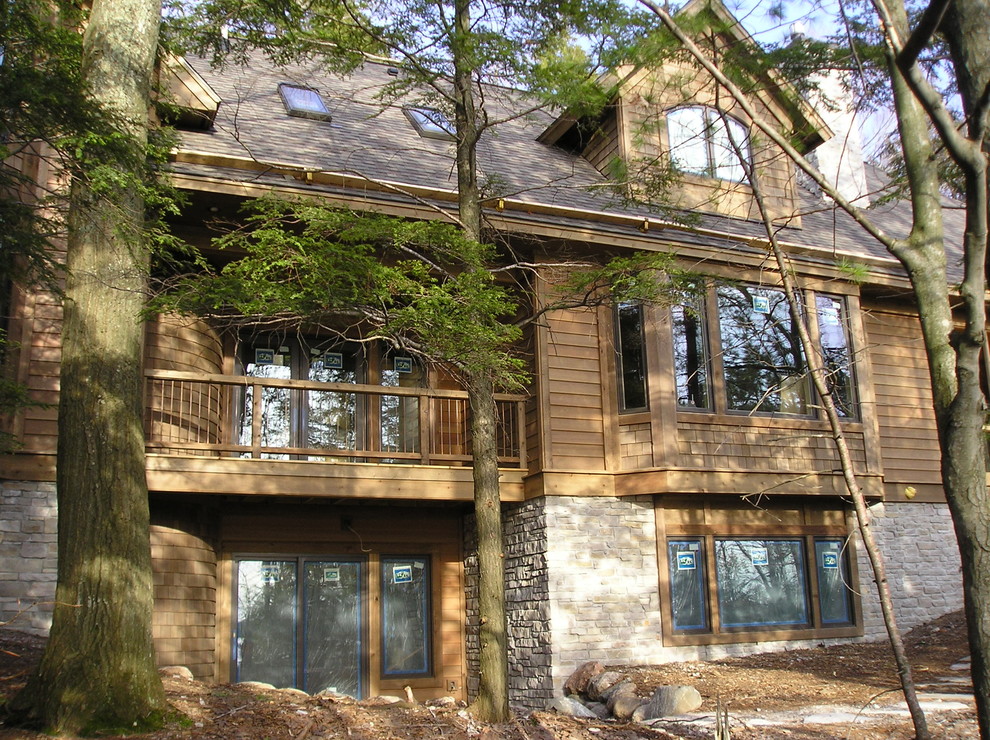 Large mountain style gray one-story vinyl exterior home photo with a hip roof