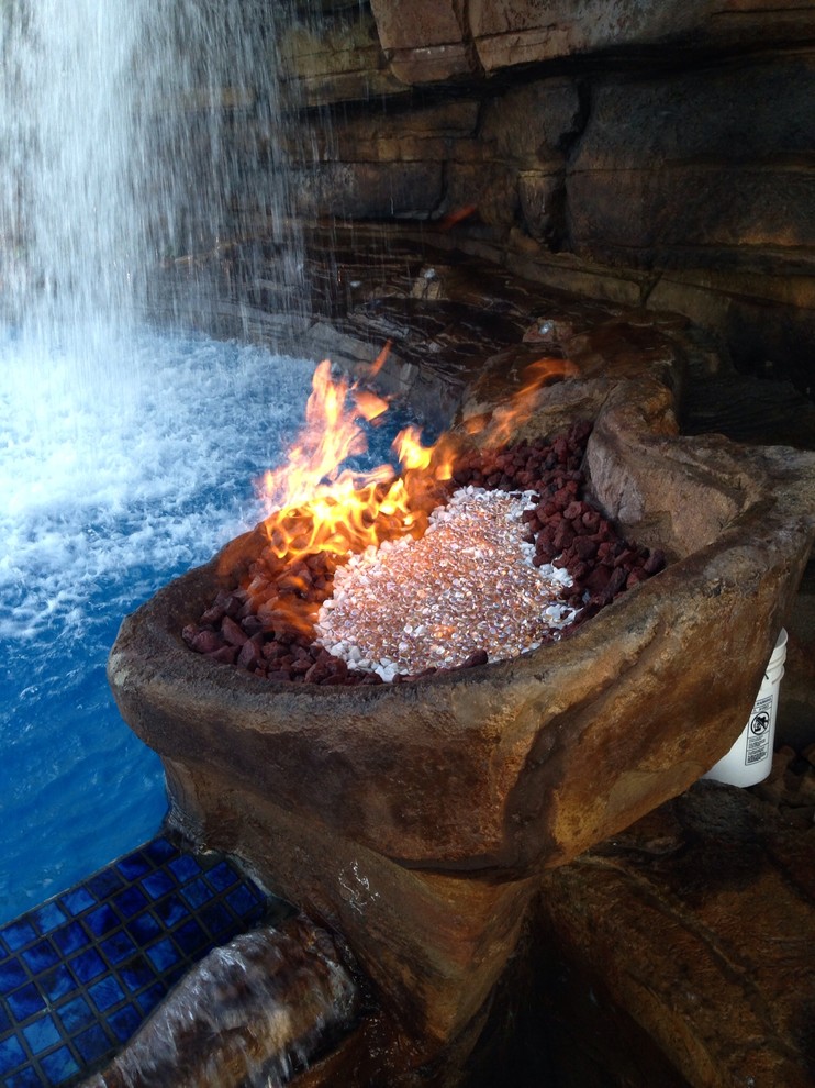 Example of a huge mountain style backyard stamped concrete and custom-shaped natural pool fountain design