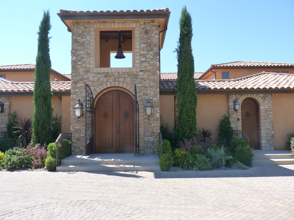 This is an example of a mediterranean two-storey beige exterior in San Diego with mixed siding.