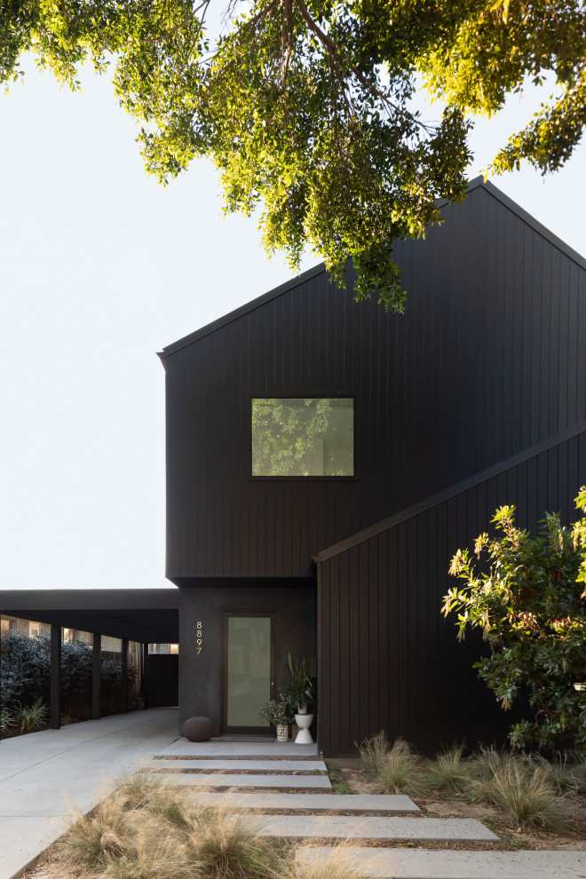 Design ideas for a small modern two-storey black house exterior in Los Angeles with wood siding, a gable roof and a metal roof.