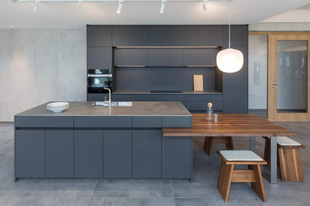 Foto di una grande cucina contemporanea con lavello a vasca singola, ante grigie, top in acciaio inossidabile, elettrodomestici neri e pavimento grigio