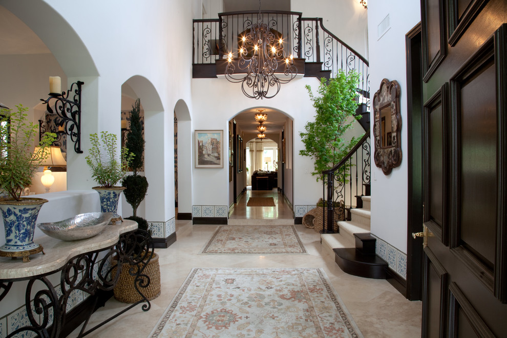 Mid-sized mediterranean foyer in Orange County with white walls, travertine floors, a single front door, beige floor and vaulted.