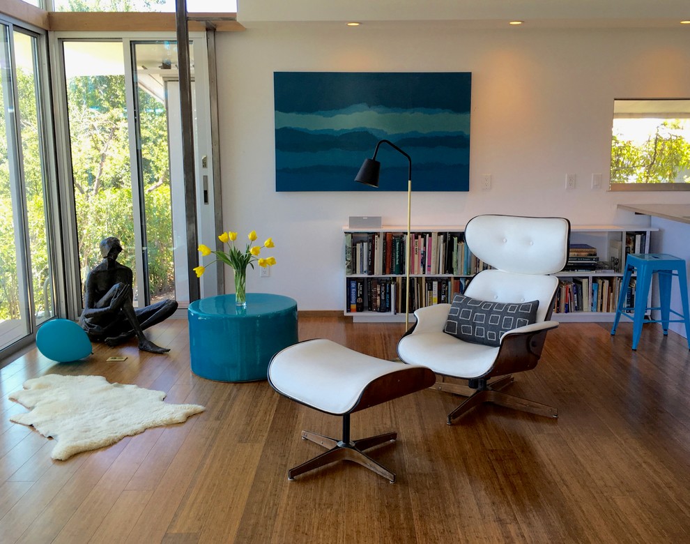 This is an example of a mid-sized midcentury open concept living room in Santa Barbara with white walls, medium hardwood floors, no fireplace, a wall-mounted tv and brown floor.