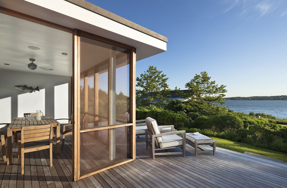 Photo of a beach style deck in New York with a roof extension.