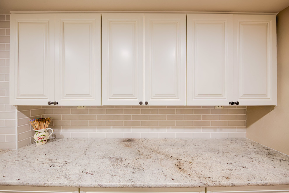 Inspiration for a large traditional galley dedicated laundry room in Phoenix with an undermount sink, raised-panel cabinets, white cabinets, quartzite benchtops, beige walls, travertine floors, a side-by-side washer and dryer and beige floor.