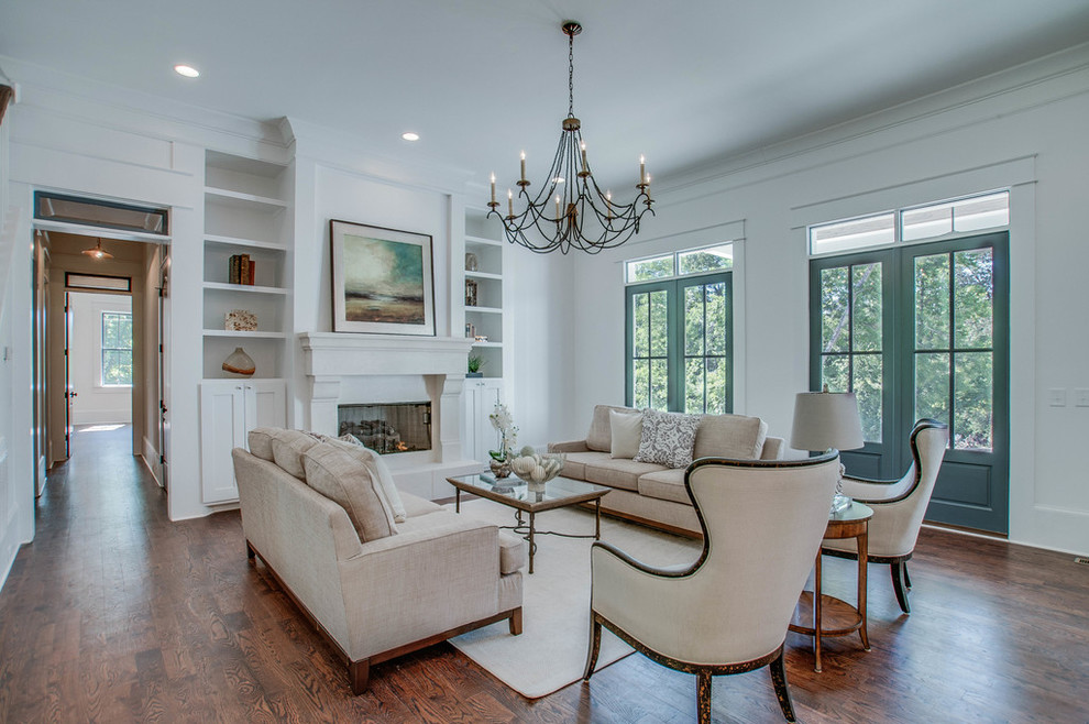 Photo of a transitional formal open concept living room in Nashville with white walls, dark hardwood floors, a standard fireplace, a plaster fireplace surround and no tv.