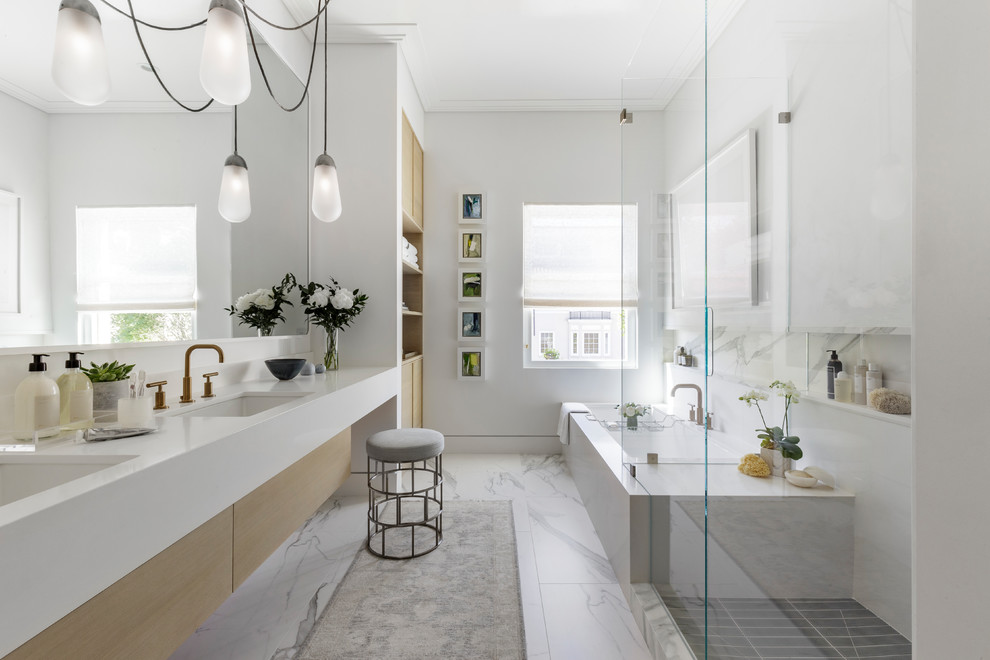 Photo of a large modern master bathroom in San Francisco with flat-panel cabinets, light wood cabinets, an undermount tub, a corner shower, white walls, marble floors, an undermount sink, engineered quartz benchtops, grey floor and a hinged shower door.