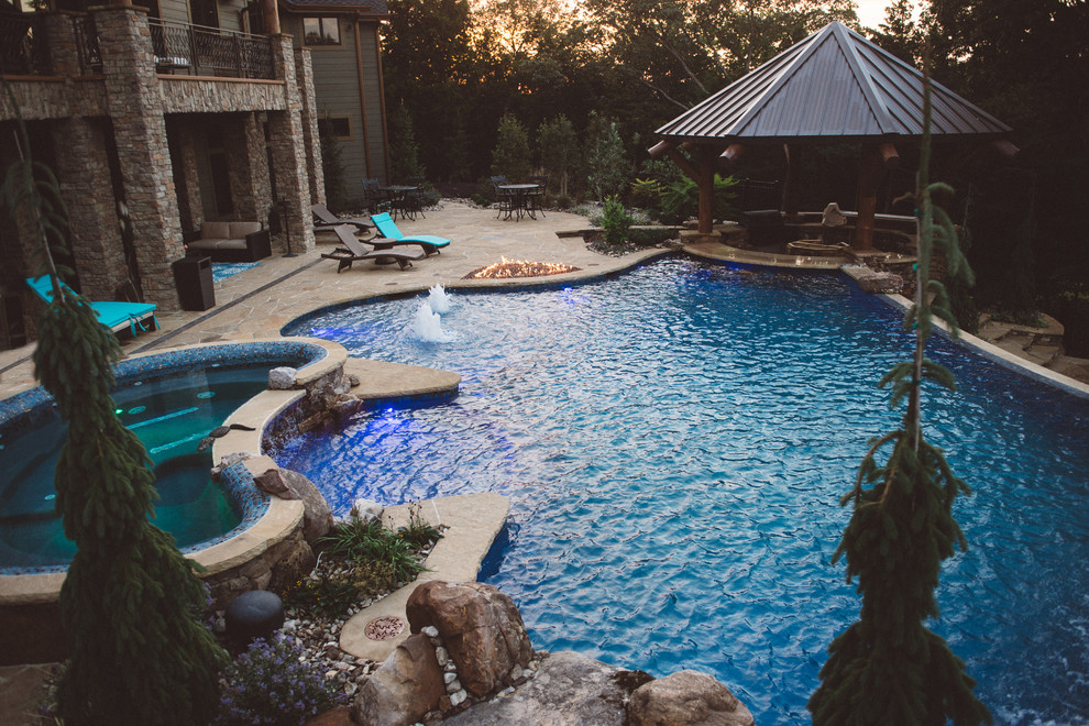 Photo of a large arts and crafts backyard custom-shaped pool in Kansas City with a water feature.