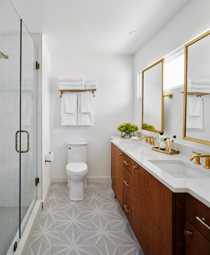 Design ideas for a small midcentury ensuite bathroom in Austin with medium wood cabinets, a walk-in shower, a one-piece toilet, white tiles, ceramic tiles, white walls, ceramic flooring, a submerged sink, engineered stone worktops, grey floors, a hinged door, white worktops, double sinks, a built in vanity unit and flat-panel cabinets.
