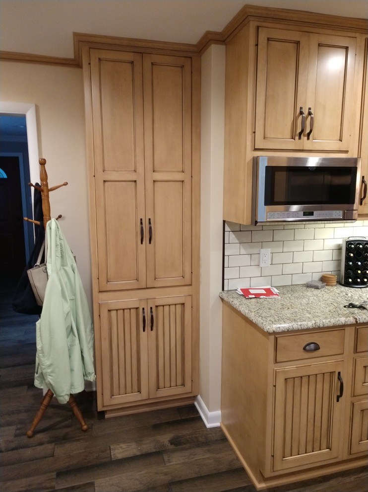 Inspiration for a mid-sized rustic laminate floor and multicolored floor home design remodel with distressed cabinets, granite countertops, white backsplash, subway tile backsplash, stainless steel appliances, no island and multicolored countertops