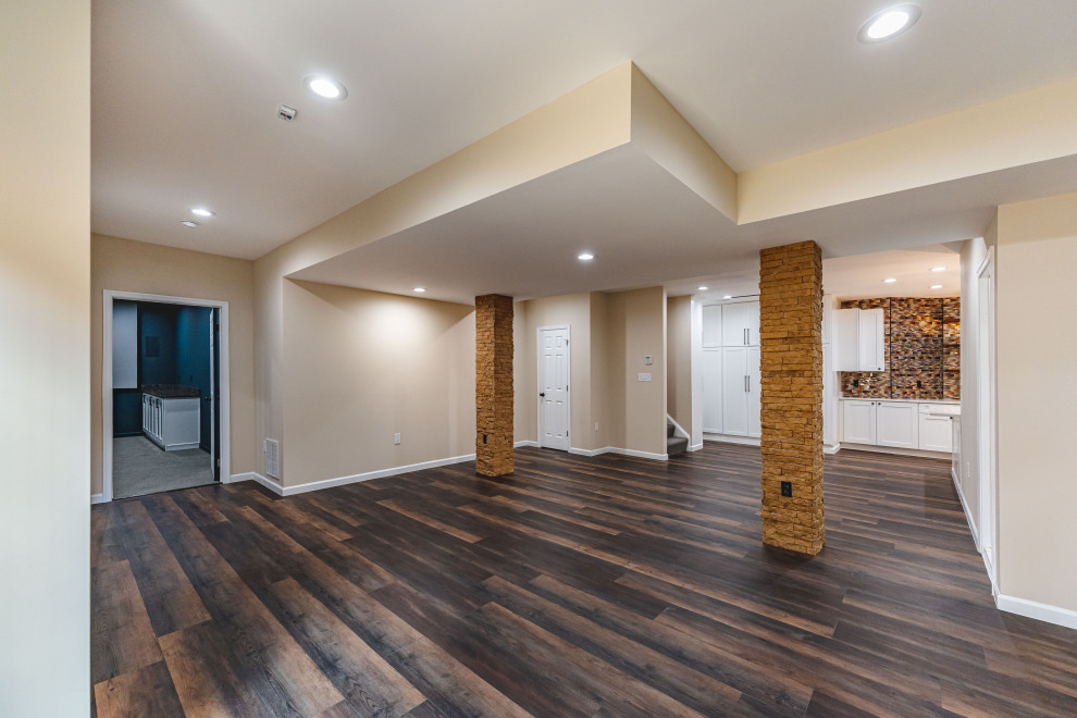 Exempel på en stor modern källare, med beige väggar, mörkt trägolv och brunt golv