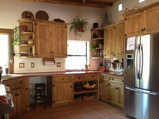 Example of a mountain style kitchen design with distressed cabinets