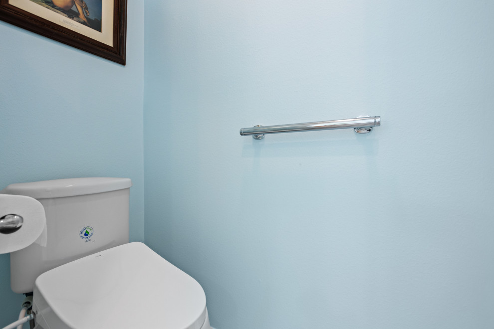 Exemple d'une petite salle de bain principale moderne en bois clair avec un placard à porte affleurante, une baignoire d'angle, une douche d'angle, un bidet, un carrelage blanc, des carreaux de porcelaine, un mur bleu, un sol en carrelage de terre cuite, un lavabo encastré, un plan de toilette en quartz modifié, un sol gris, une cabine de douche à porte battante, un plan de toilette blanc, un banc de douche, meuble simple vasque, meuble-lavabo suspendu et un plafond voûté.