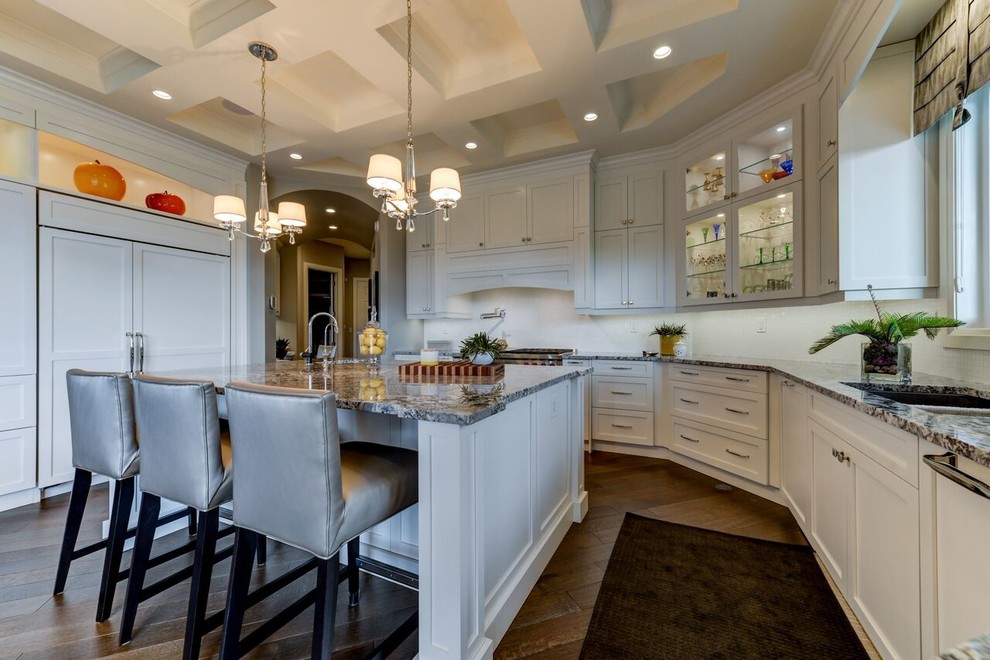 Kitchen - large transitional u-shaped medium tone wood floor and brown floor kitchen idea in Edmonton with shaker cabinets, white cabinets, granite countertops, white backsplash, an island, an undermount sink, glass tile backsplash and paneled appliances