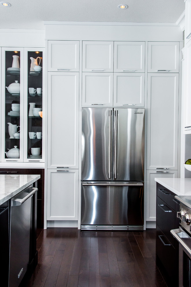 Eat-in kitchen - mid-sized transitional l-shaped medium tone wood floor eat-in kitchen idea in Calgary with shaker cabinets, white cabinets, quartz countertops, stainless steel appliances, an island, multicolored backsplash, mosaic tile backsplash and an undermount sink