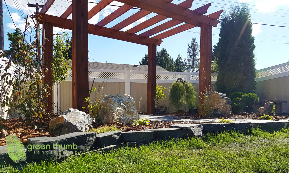 Photo of a rustic full sun backyard stone retaining wall landscape in Edmonton for summer.