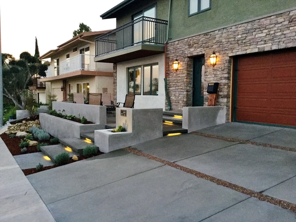 Photo of a large modern front yard driveway in Los Angeles with a retaining wall.