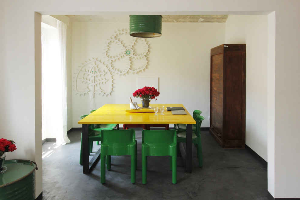Eclectic dining room in Turin with white walls, black floor and concrete floors.
