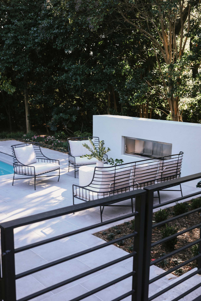 Großes Modernes Sportbecken hinter dem Haus in rechteckiger Form mit Pool-Gartenbau und Natursteinplatten in Sonstige