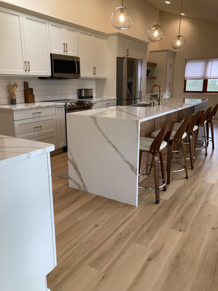 Large contemporary l-shaped eat-in kitchen in Other with shaker cabinets, white cabinets, quartz benchtops, white splashback, subway tile splashback and with island.