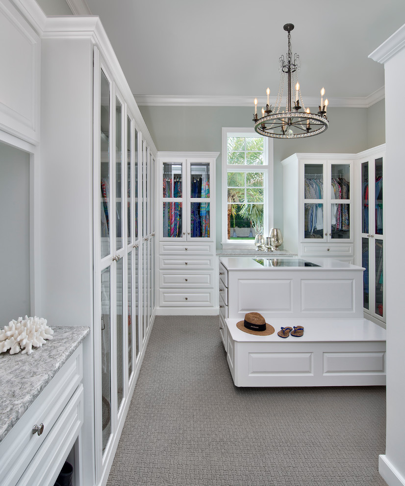 This is an example of a large transitional women's walk-in wardrobe in Other with raised-panel cabinets, white cabinets, carpet and grey floor.