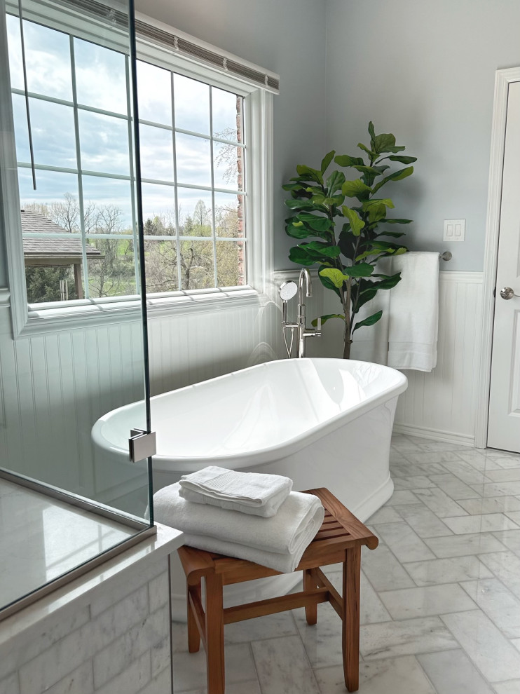 Mid-sized transitional master gray tile and marble tile marble floor, gray floor, double-sink and wainscoting freestanding bathtub photo with shaker cabinets, white cabinets, a two-piece toilet, blue walls, an undermount sink, quartz countertops, a hinged shower door, gray countertops and a built-in vanity
