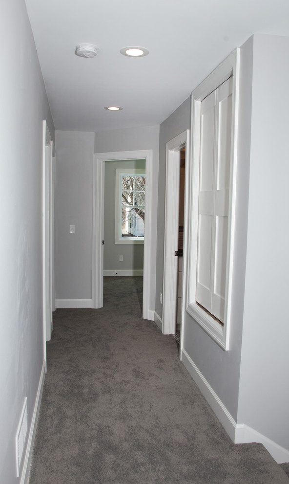 Mid-sized transitional hallway in Minneapolis with grey walls and carpet.