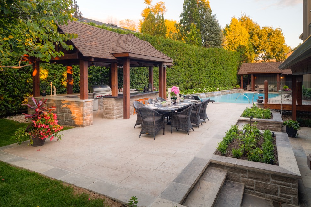Inspiration for a large traditional backyard patio in Toronto with stamped concrete.