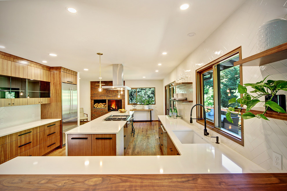 Inspiration for a large 1950s l-shaped medium tone wood floor and brown floor eat-in kitchen remodel in Seattle with an undermount sink, flat-panel cabinets, medium tone wood cabinets, quartz countertops, white backsplash, subway tile backsplash, stainless steel appliances and an island