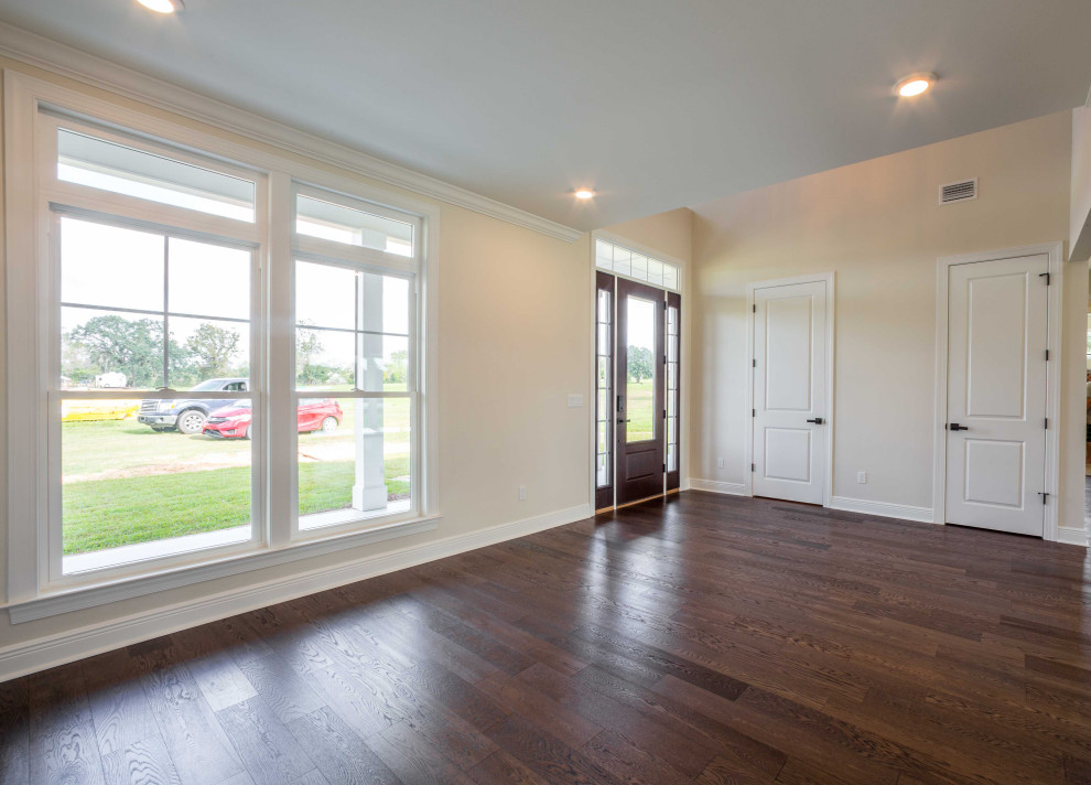 Inspiration for a mid-sized timeless medium tone wood floor and brown floor foyer remodel with beige walls and a brown front door