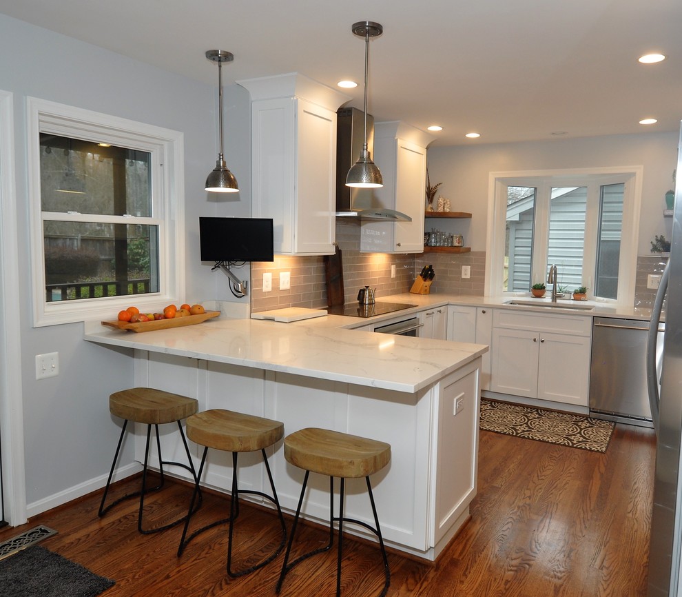 Photo of a mid-sized transitional u-shaped eat-in kitchen in DC Metro with white cabinets and stainless steel appliances.