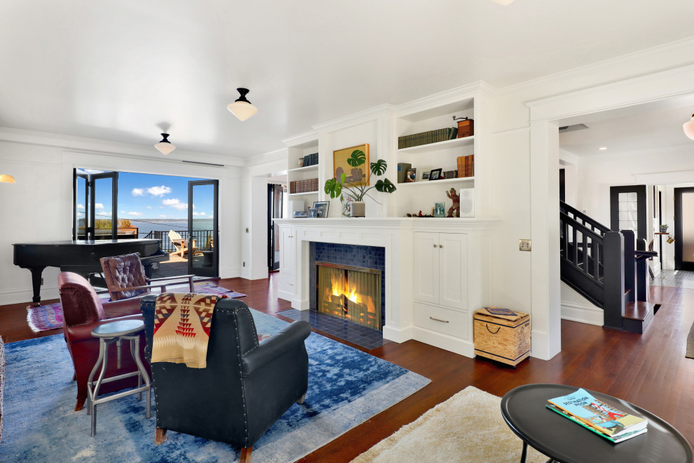 Photo of a large arts and crafts formal open concept living room in Seattle with white walls, light hardwood floors, a standard fireplace, a tile fireplace surround and orange floor.