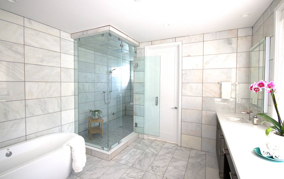 Example of a large minimalist master white tile and stone tile marble floor, white floor and double-sink bathroom design in San Diego with flat-panel cabinets, dark wood cabinets, a wall-mount toilet, white walls, an undermount sink, solid surface countertops, a hinged shower door, white countertops and a built-in vanity